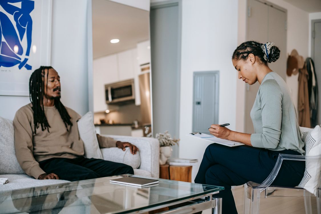 Stock photo of a therapist and a man in a supportive conversation